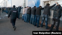 На фото російська поліція перевіряє трудових мігрантів. Слідоком Росії: «понад 30 тисяч трудових мігрантів вже зловили і поставили на облік» 