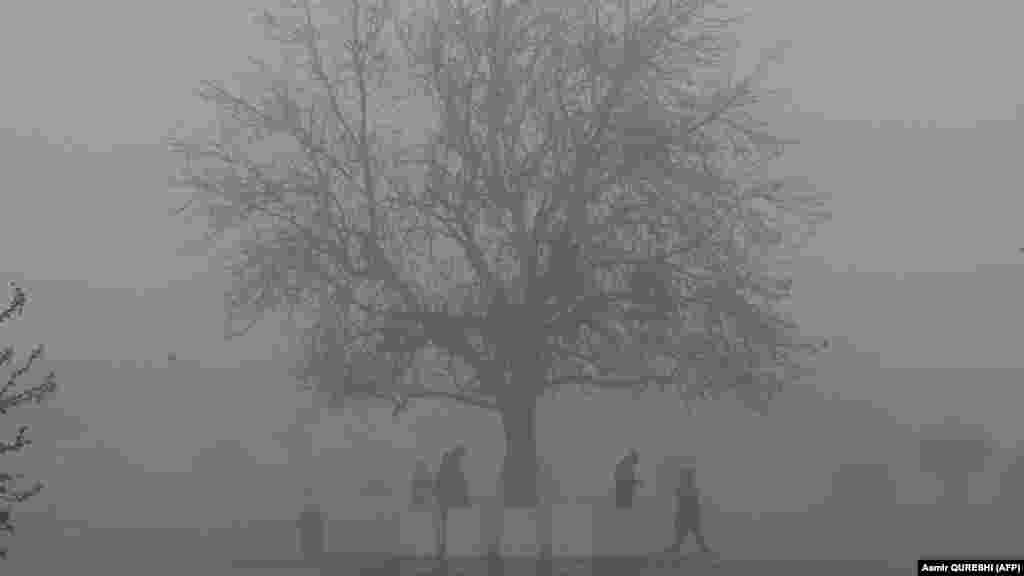 Ljudi prolaze parkom koji je prekriven maglom u pakistanskom glavnom gradu Islamabadu.