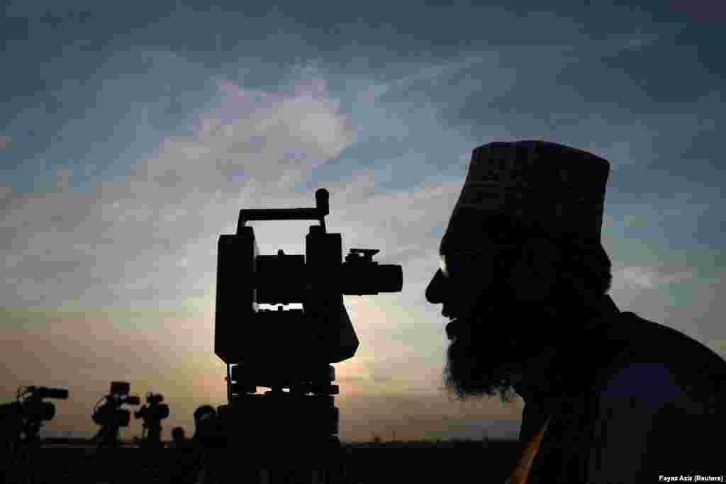 In Peshawar, a member of the moon-sighting committee is silhouetted as he uses a theodolite, a surveyor&#39;s instrument, to look for the new moon. After the sighting of the crescent moon, the committee announced the beginning of Ramadan for March 12. &nbsp;