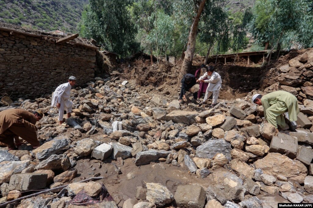 Gli abitanti del distretto di Watapur, nella provincia di Kunar, rimuovono i detriti vicino alle loro case.