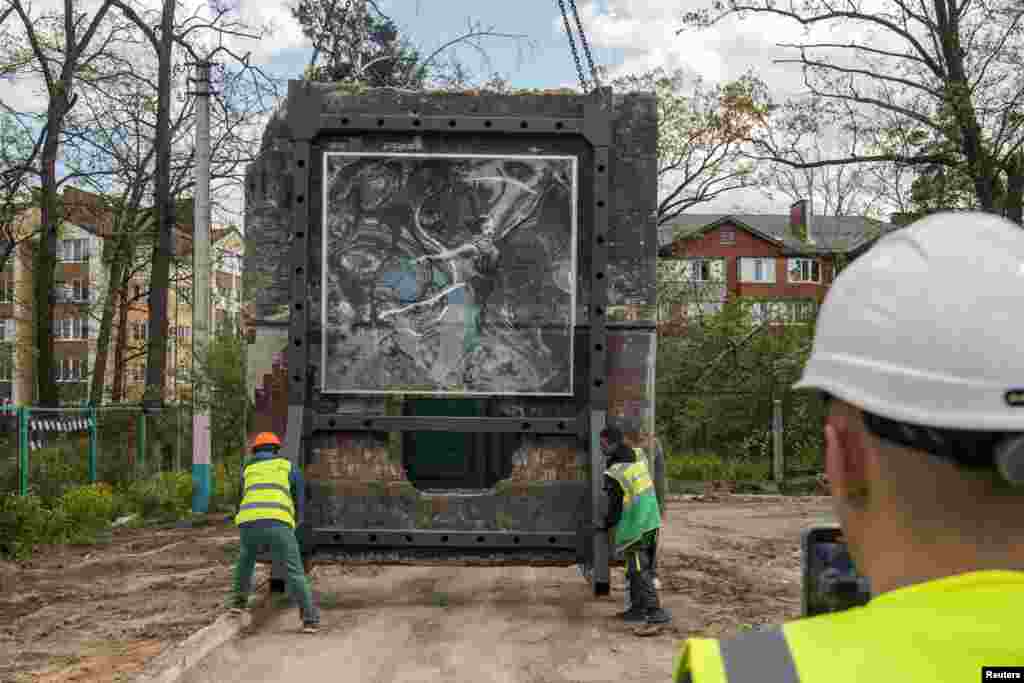 Radnici istovaruju dio zida oslikan djelom svjetski poznatog grafiti umjetnika Banksyja, koji je skinut s zgrade koja je oštećena u ruskom napadu na ukrajinski grad Irpin, 13. maj.