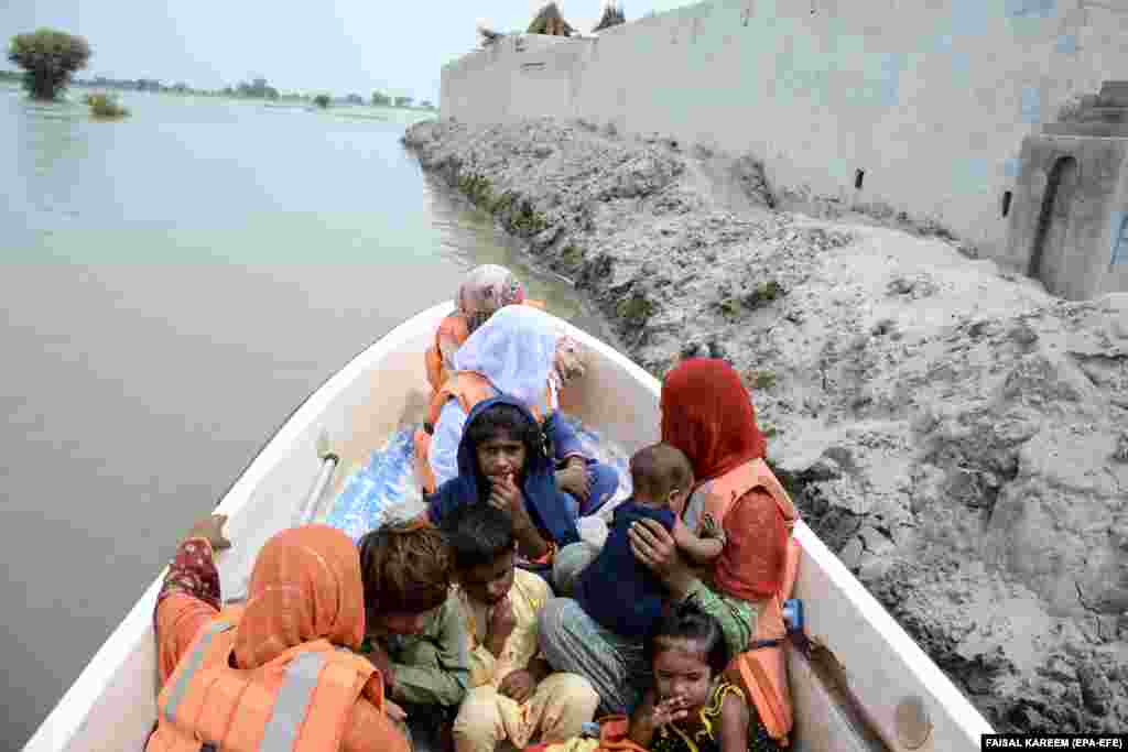 Salvatorii evacuează sinistrații din zonele inundate din Noora Nath, provincia Punjab, Pakistan.