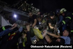 Rescues and volunteers carry a woman rescued from the debris at the site of a Russian missile strike in central Kramatorsk, Donetsk region, Ukraine, on June 27.