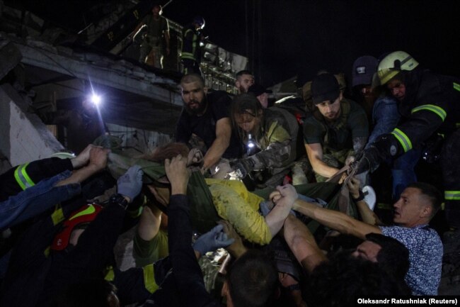 Rescues and volunteers carry a woman rescued from the debris at the site of a Russian missile strike in central Kramatorsk, Donetsk region, Ukraine, on June 27.