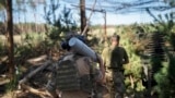 Український військовий несе снаряд до гаубиці на околиці Лиману, 15 серпня 2023 року