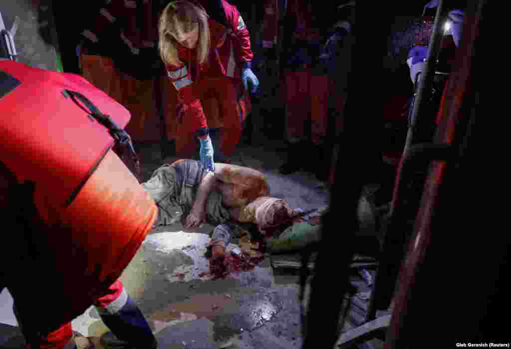 Medical workers treat a wounded resident of a damaged building following the Russian missile attack in Kyiv. The Russian barrage included more than 40 ballistic, cruise, anti-aircraft, and guided missiles, officials said. Ukraine&#39;s air force claimed to have intercepted 21 of them. &nbsp;