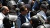 Police officers escort former Pakistani Prime Minister Imran Khan (center) as he arrives at the high court in Islamabad on May 12.