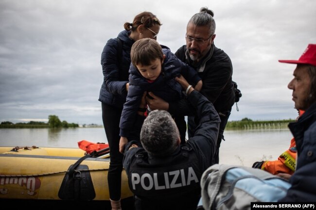 Një fëmijë duke u shpëtuar nga vërshimet në Masa Lombardia më 17 maj.
