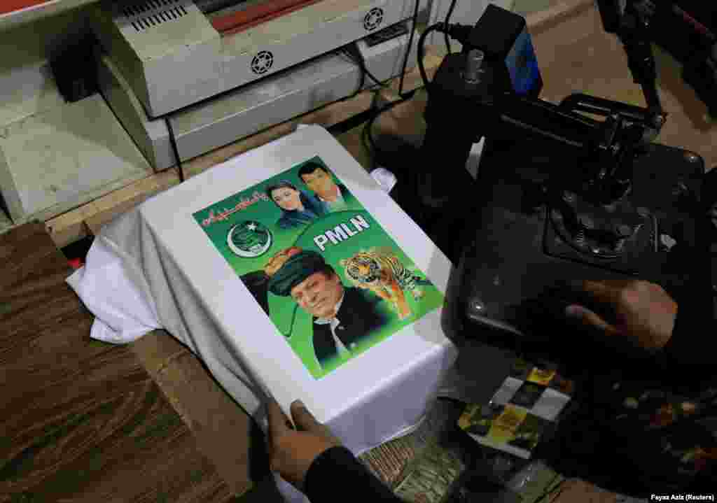 A worker prints a poster depicting former Prime Minister Nawaz Sharif, who leads the Pakistan Muslim League-N. The symbol for PML-N is a tiger. A total of 147 symbols representing animals, inanimate objects, flowers, and even combat aircraft are visible across the country. &nbsp;
