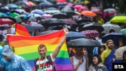 People brave the rain to attend the Pride Parade in Sofia on June 17.
