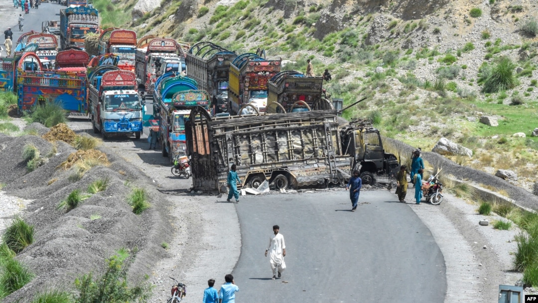 People look at a charred vehicle near a collapsed railway bridge a day after a blast by separatist Baloch Liberation Army militants at Kolpur in Bolan district, Balochistan Province, on August 27.