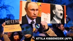 Плакат с изображением Владимира Путина и Адольфа Гитлера на акции у посольства РФ в Венгрии во вторую годовщину масштабного вторжения России в Украину. Будапешт, 24 февраля 2024 года.