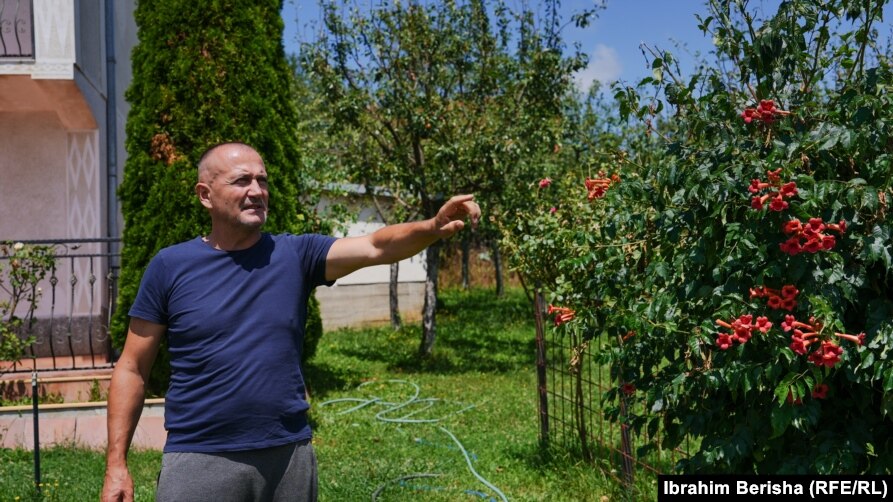 Fatmir Mjekiqi duke qëndruar në oborrin e shtëpisë, një pjesë e të cilit i është shpronësuar.
