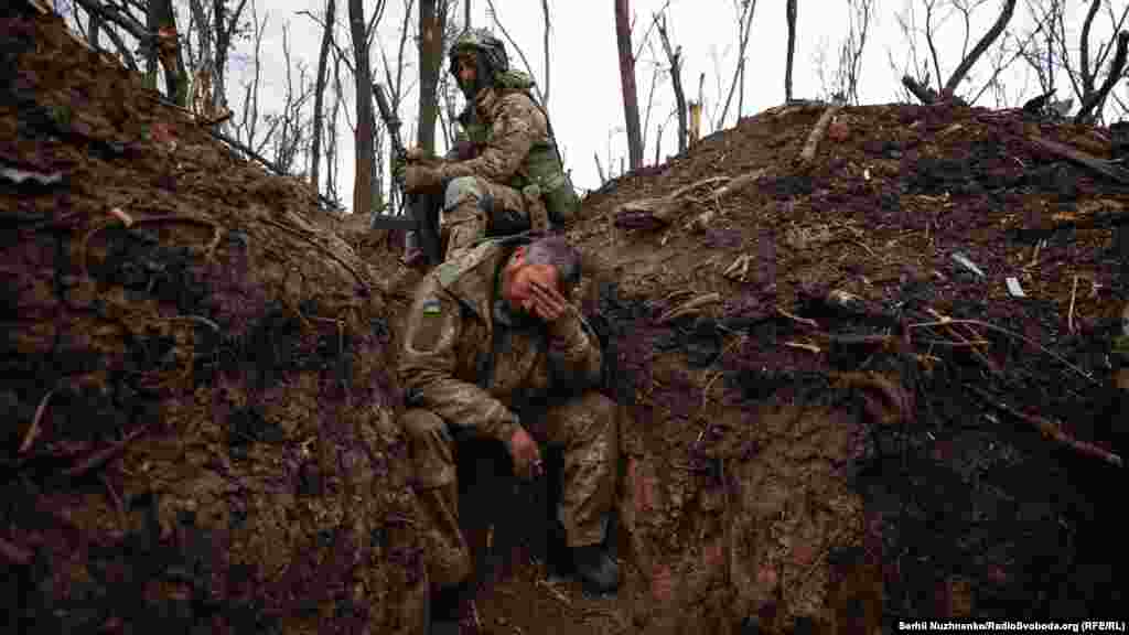 A weary Ukrainian soldier rests in a trench. Moments earlier, the assault vehicle (BMP) he was traveling in ran over an anti-tank mine.