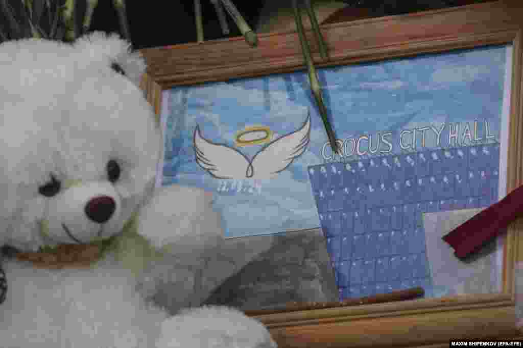 A toy teddy bear and a drawing are seen at the impromptu memorial.