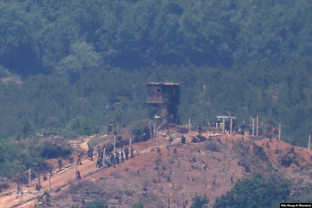 Njerëzit e Koresë së Veriut duke punuar në një gardh ushtarak pranë pikës së tyre të rojës në kufirin mes dy Koreve. Fotografia është marrë nga kuverta e vëzhgimit pranë zonës së çmilitarizuar që ndan dy Koretë në Paju, Koreja e Jugut, 4 qershor 2024