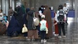 Kyrgyz women and children arrive in Bishkek from a Syrian refugee camp in August.