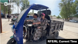 Sirojiddin Toghaev gives a ride to his sister Oibahor on his mobility scooter.