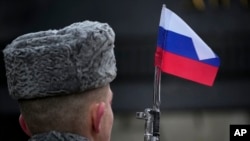 Një ushtar me flamurin rus afër.