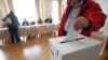 Egy szavazó bedobja a szavazólapját az urnába a londoni külképviseleti szavazókörben, a magyar nagykövetségen az európai parlamenti választások napján, 2014. május 25-én