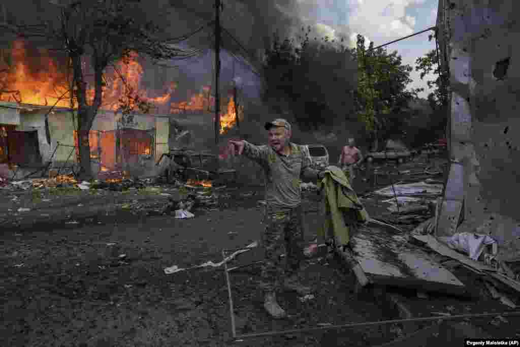 Një ushtarak ukrainas thërret ndihmësit e mjekëve ndërsa shihen trupa të të vrarëve nga sulmet rus me raketa në një dyqan ushqimor në qendër të qytetit të Kostiantnjivk, Ukrainë, 6 shtator 2023.