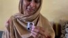 Tazeem Pervaiz, the mother of migrant Taquir Pervaiz, who is missing after an overloaded trawler capsized and sank in the Ionian Sea, weeps while holding a picture of her son in Bandli village in Pakistan-administered Kashmir.