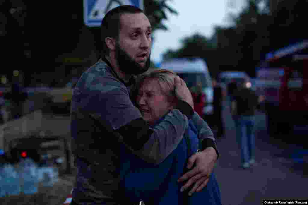 A man comforts a woman at the site of the building heavily damaged by a Russian missile strike in Kramatorsk. &nbsp;