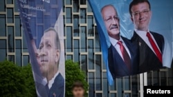 Transparent sa likom turskog predsednika Erdoana (levo) i njegovog izbornog protivkandidata Kiličdarolua (drugi s desna) u Istanbulu, Turska, 12. maj 2023.