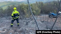 Vatrogasac na zgarištu nakon požara na području grada Negotino, na sjeveru zemlje, juli 2024.