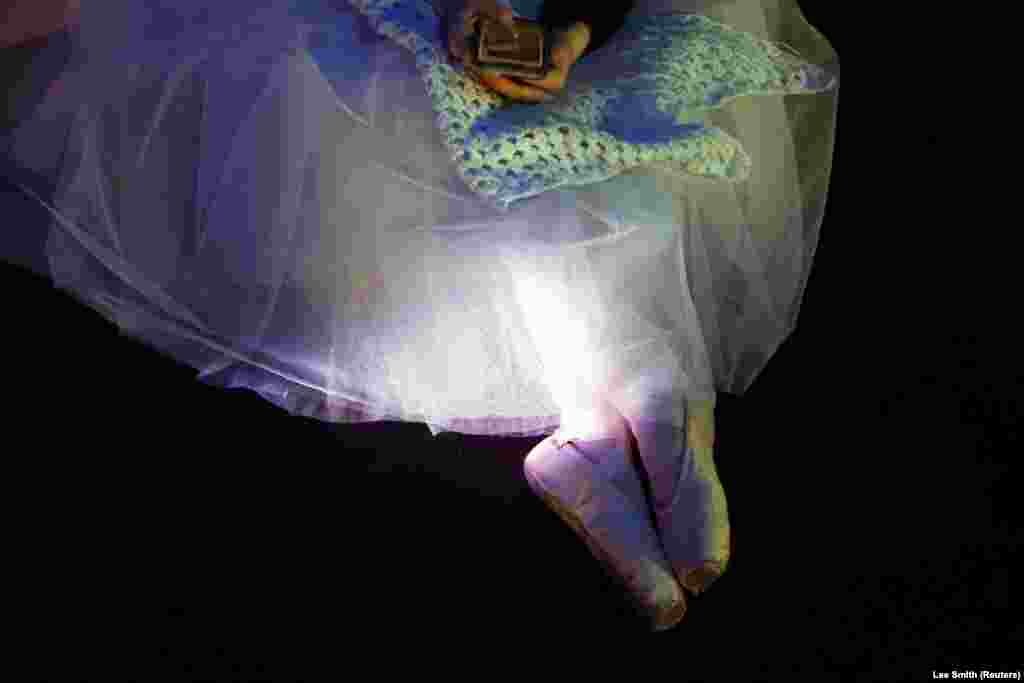 A ballerina from the Kyiv City ballet looks at her phone during the dress rehearsal for the opening night gala performance at the York Theater Royal in York, England, on March 30.