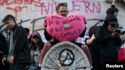 Demonstrant drži veliko plišano srce sa sloganom "Makron, mrzim te svim srcem", na Trgu Republike nakon delimičnih rezultata u drugom krugu prevremenih parlamentarnih izbora u Francuskoj, u Parizu, 7. jul 2024.