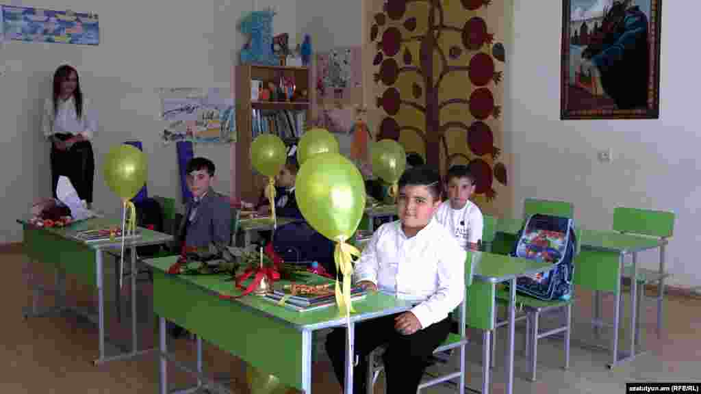 Students with green balloons wait patiently for the start of class in a school in the Armenian village of Jrap.