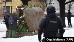 Сотрудники ОМОНа у памятника жертвам политических репрессий, куда приходят, чтобы возложить цветы Алексею Навальному в Санкт-Петербурге
