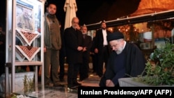 Președintele iranian Ebrahim Raisi (dreapta) se reculege la mormântul generalului Qasem Soleimani, ucis într-un atac american cu dronă în urmă cu patru ani, în Kerman. 5 ianuarie 2024 (foto: Președinția Iranului / AFP)
