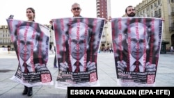 Плакаты с изображением российского президента Владимира Путина за решеткой на акции против войны в Украине. Италия, Турин, 20 августа 2023 года