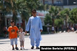 Mahmood Rezaie, afgan që po strehohet në Shqipëri, duke shëtitur me djemtë e tij rreth plazhit të Shëngjinit.