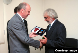 Михайло Рамач (праворуч) отримує Орден Ярослава Мудрого в посольстві України в Белграді