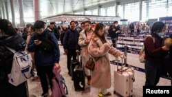 Ljudi u redu za sigurnosnu provjeru na aerodromu u Harbinu, pokrajina Heilongjiang, Kina, 8. januara 2024.