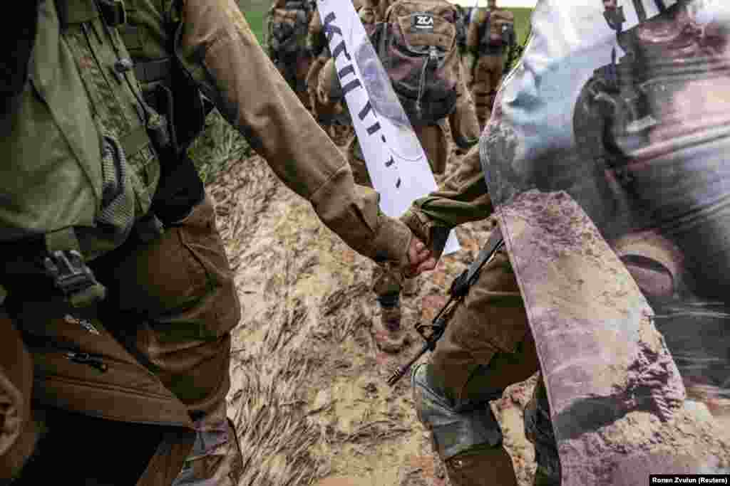 Anëtarët e Brigadës së Kërkimit dhe Shpëtimit të Izraelit kapen për dore gjatë një marshi intensiv, para se t&#39;i marrin beretat e brigadës.