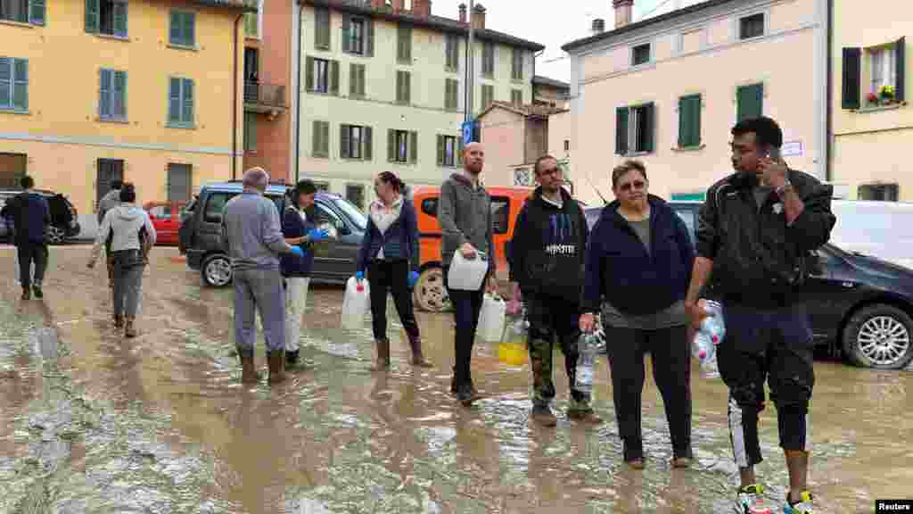 Oamenii stau la coadă pentru apă potabilă în Castel Bolognese, localitate din regiunea Emilia Romagna/Italia, 18 mai 2023. REUTERS/Jennifer Lorenzini