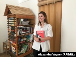 Вера Лёгких рядом с библиотекой, для которой она подбирает книги