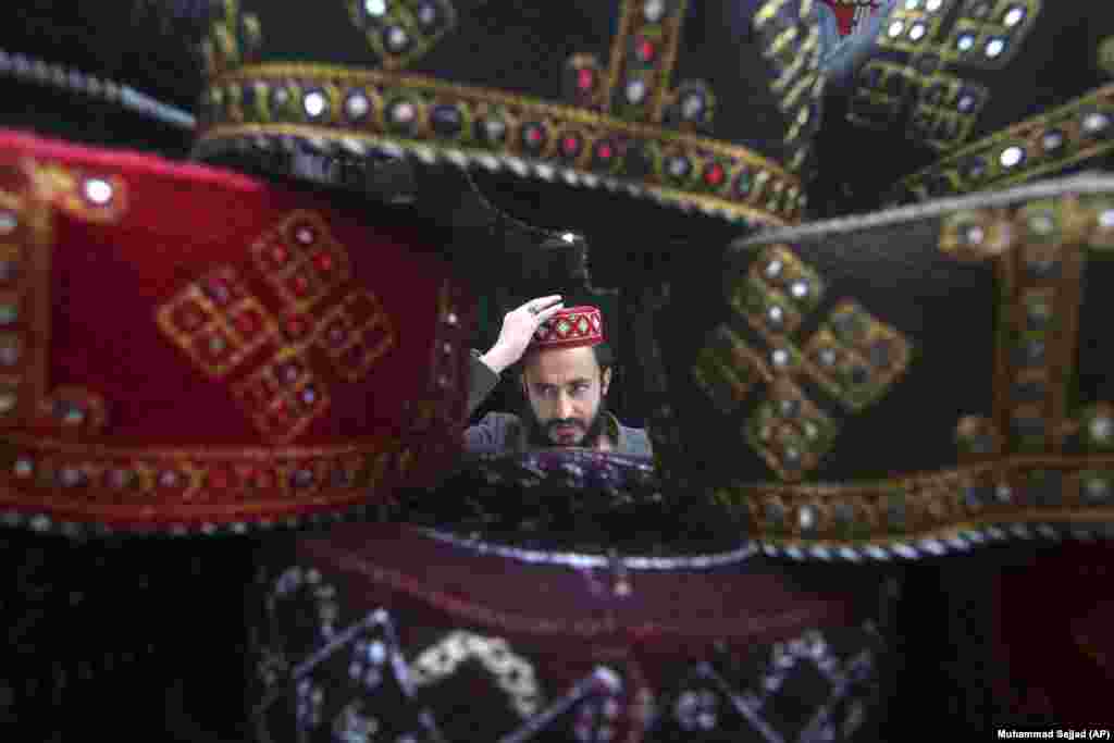 A man tries on a traditional cap that will be used for praying during the holy month in Peshawar. &nbsp;