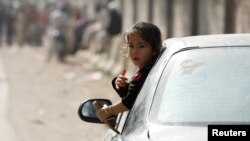 An Afghan girl looks out from a car window as her family returns home, after Pakistan ordered undocumented migrants to leave the country. 
