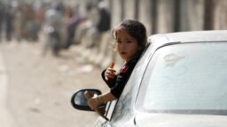 An Afghan girl looks out from a car window as her family returns home, after Pakistan ordered undocumented migrants to leave the country. 