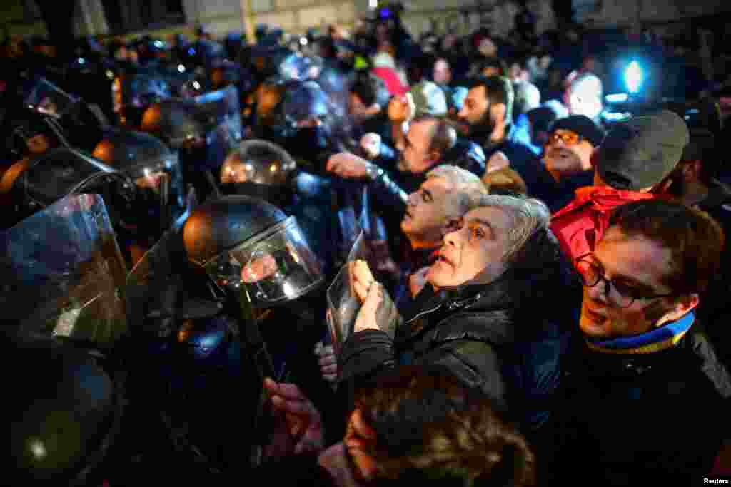 Протестиращи се събират пред полицейски служители, които блокират пътя по време на протестите срещу закона за &quot;чуждите агенти&quot; в Тбилиси. Протестите идват и в момент, в който бившият президент на Грузия&nbsp;Михаил Саакашвили е в ареста&nbsp;без достъп до адекватни медицински грижи, независимо от тежкото му здравно състояние. Правозащитници твърдят, че той е оставен да умре заради това, че е личен враг на руския президент Владимир Путин, който има силно влияние върху управляващите в Грузия.