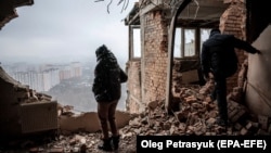 Local resident Tetyana inspects her ruined apartment at the site of a drone attack on a residential building in Kyiv on December 22, 2023.