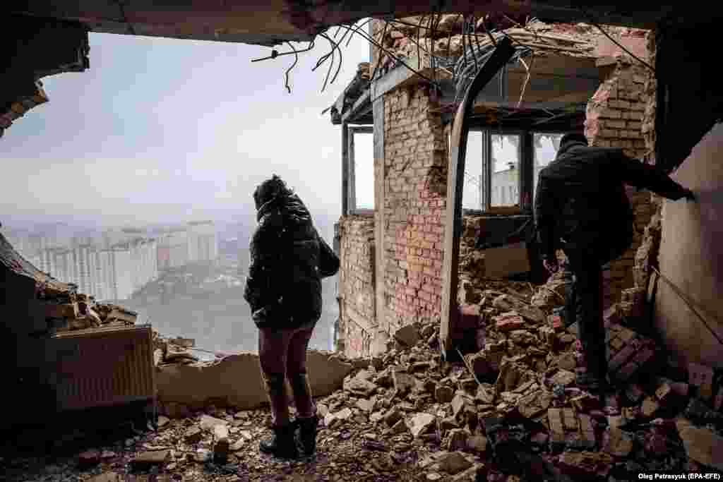 A Ukrainian woman inspects her ruined apartment, which was hit in a Russian drone attack on Kyiv.&nbsp;