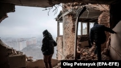 Lokalna stanovnica Tetjana gleda svoj uništeni stan na mjestu napada dronom na stambenu zgradu u Kijevu 22. decembra 2023.