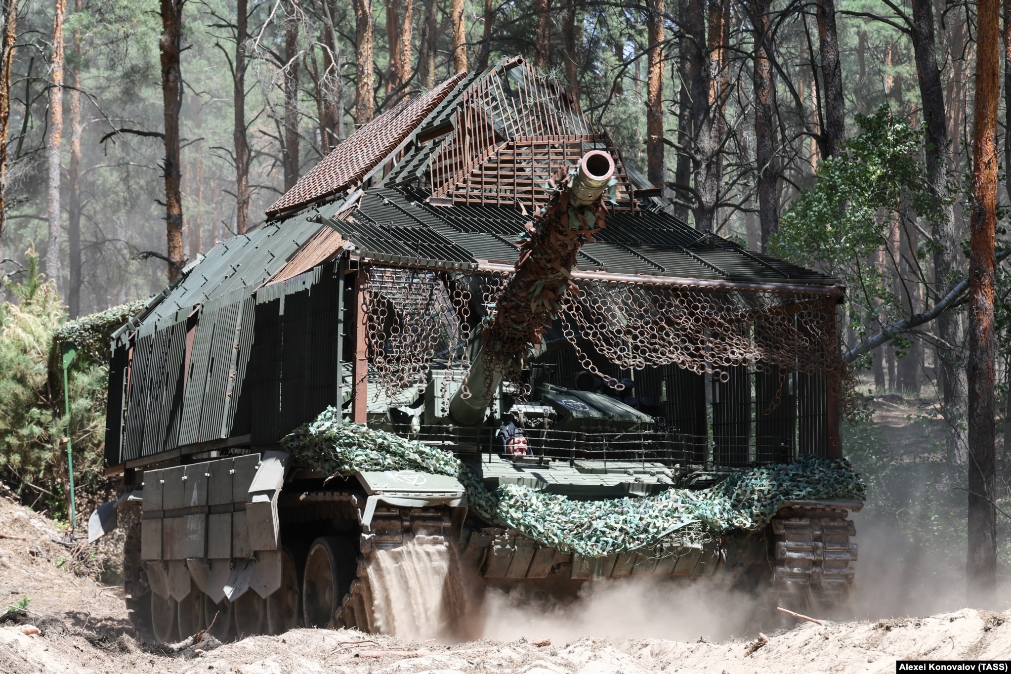 Other turtle tanks use more lightweight slat armor, such as this Russian T-72. The hanging chains in front of the driver may stop drones from getting through while also allowing some turret movement and an escape route for the crew. The modified tank was photographed in Ukraine’s Kherson region in June. 