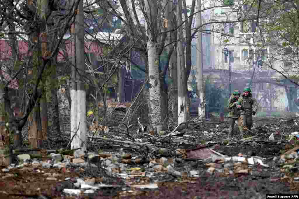 Doi soldați ucraineni patrulează în orașul devastat de pe linia frontului, Bahmut, pe 23 aprilie. Forțele rusești au declanșat mai multe valuri de asalt în cursul zilei trecute, dar niciuna dintre părți nu a reușit să facă progrese critice în bătălia de o lună pentru orașul distrus, a declarat marți armata ucraineană.